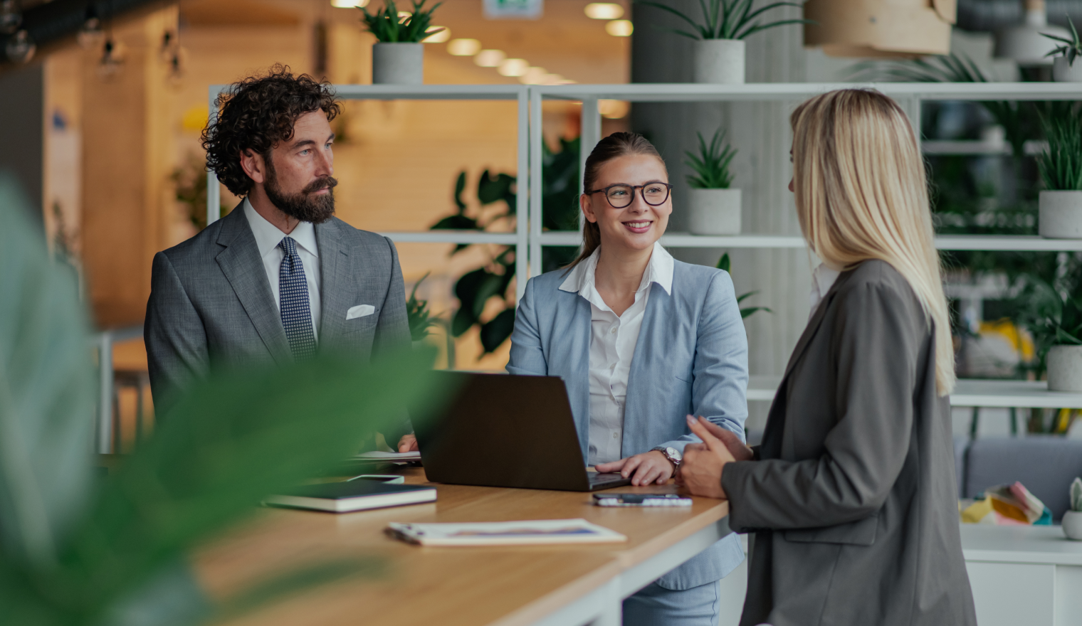 three business professionals gathered at desk