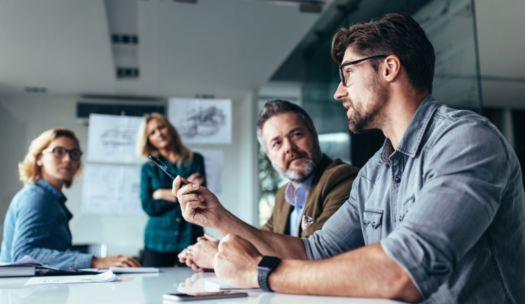 A group of business professionals having a collaborative meeting around a table in a modern office.