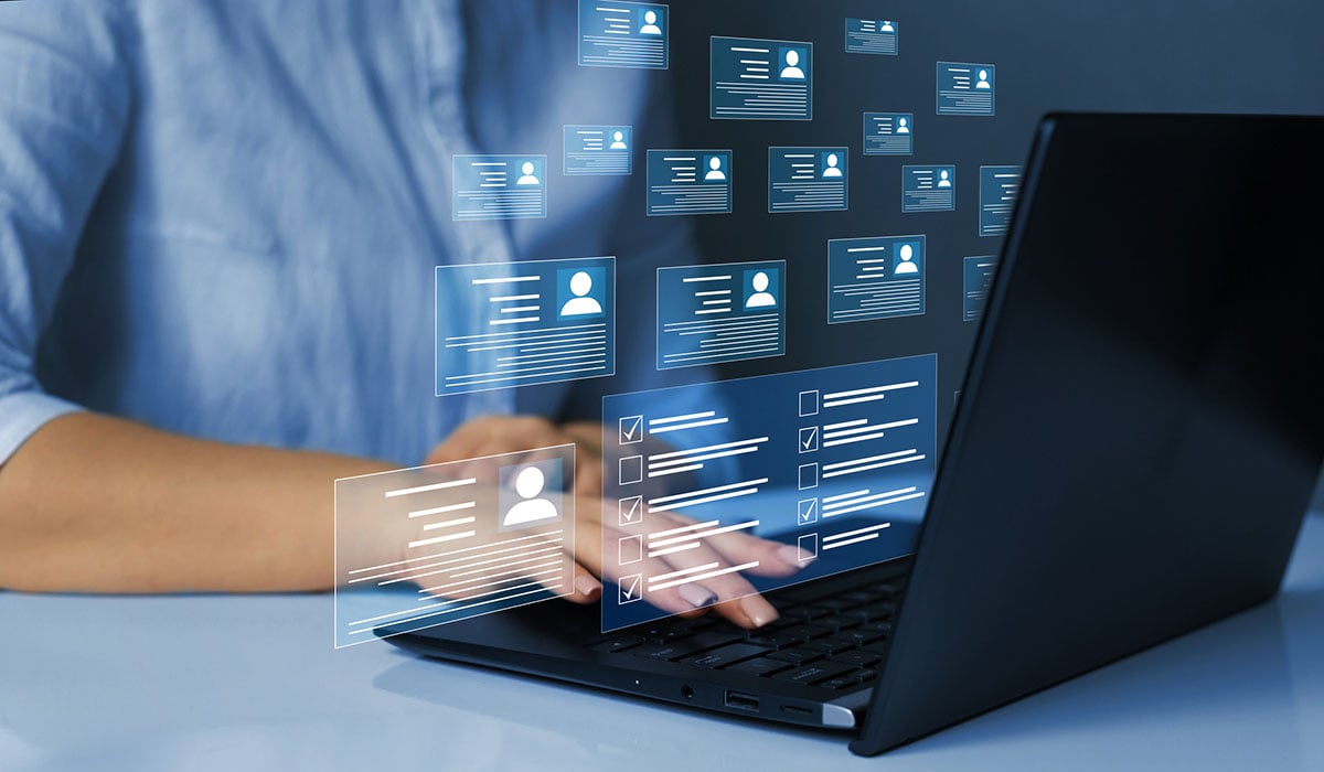 Person working on a laptop with floating translucent UI cards displaying user profile avatars, access checklists, and identity security workflows.