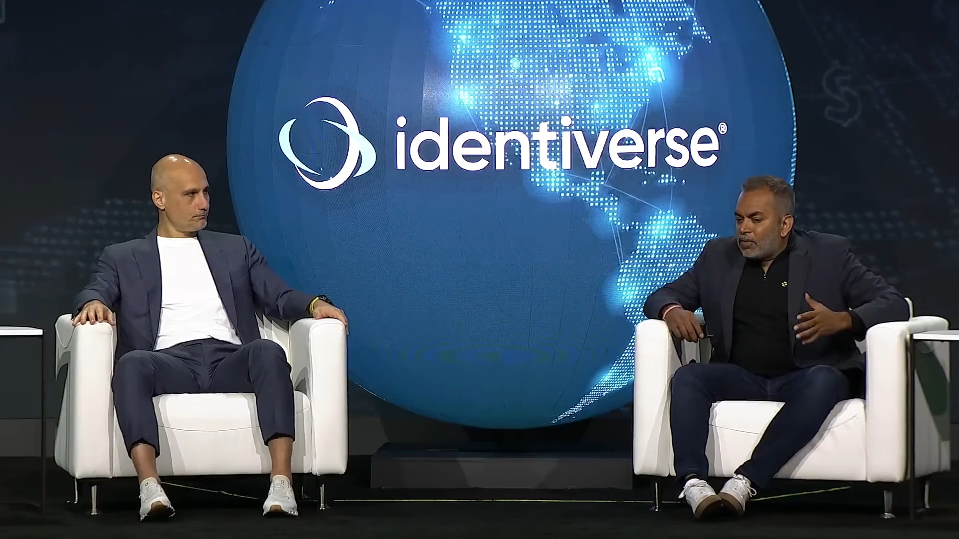 Jamil Farshchi (CTO of Equifax) and Sachin Nayyar (Founder &amp; CEO of Saviynt) speaking on stage at Identiverse during a fireside chat on AI agent security.