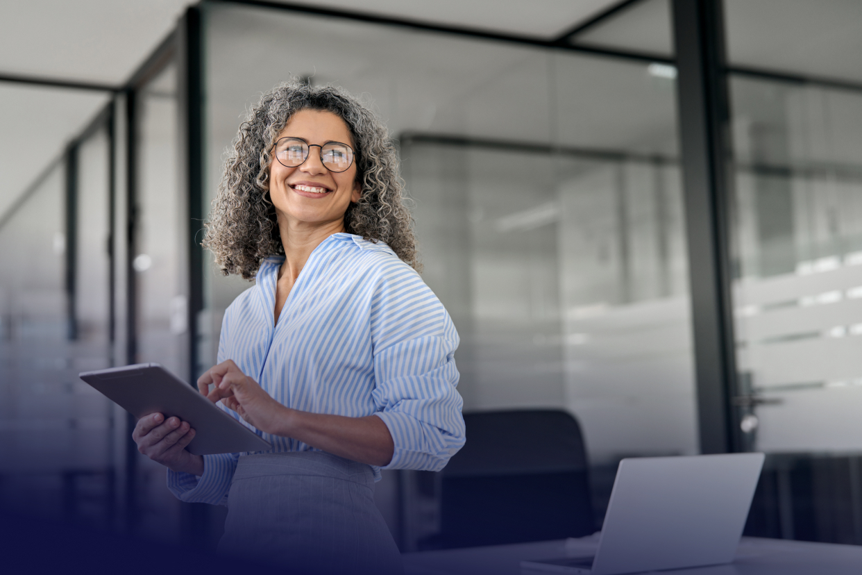 Female office worker smiling and holding tablet