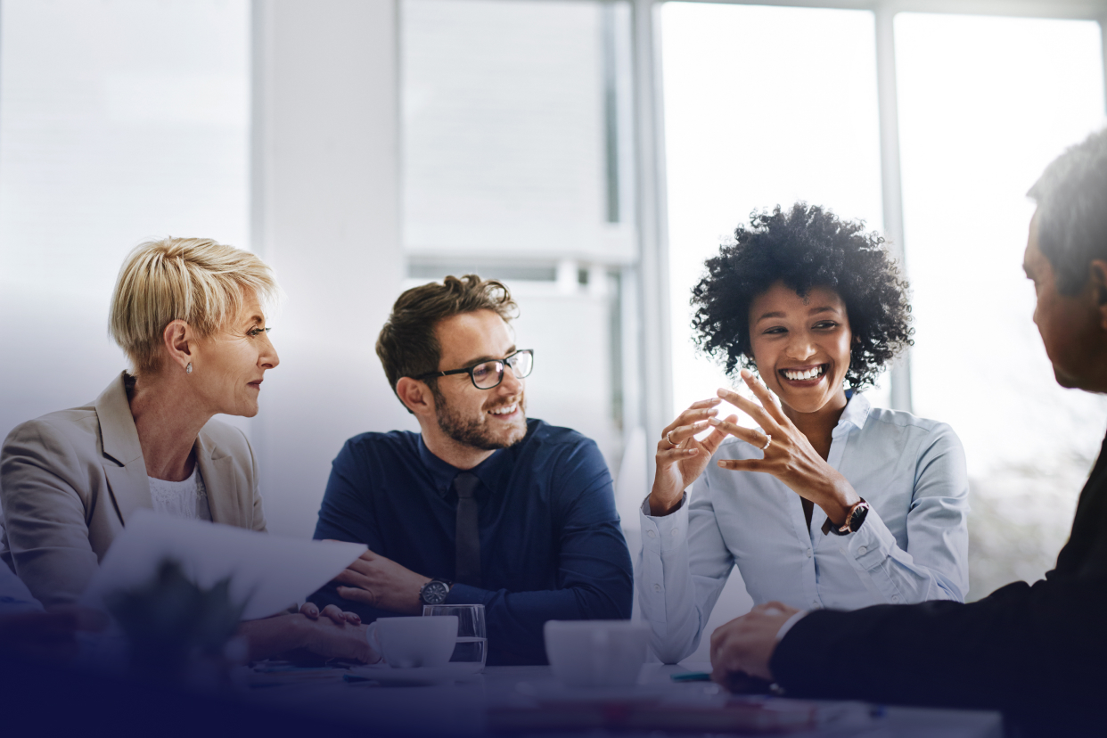 Office coworkers smiling around conference room table