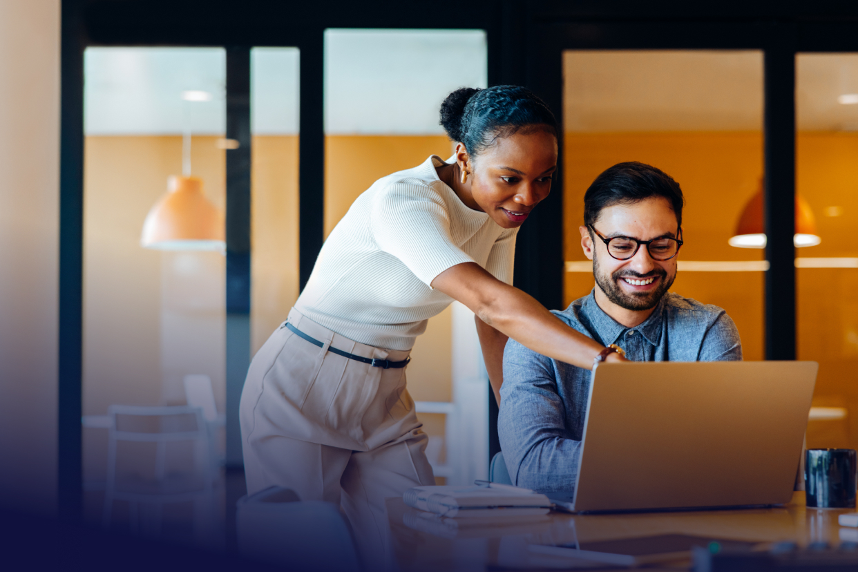 two office coworkers looking at laptop