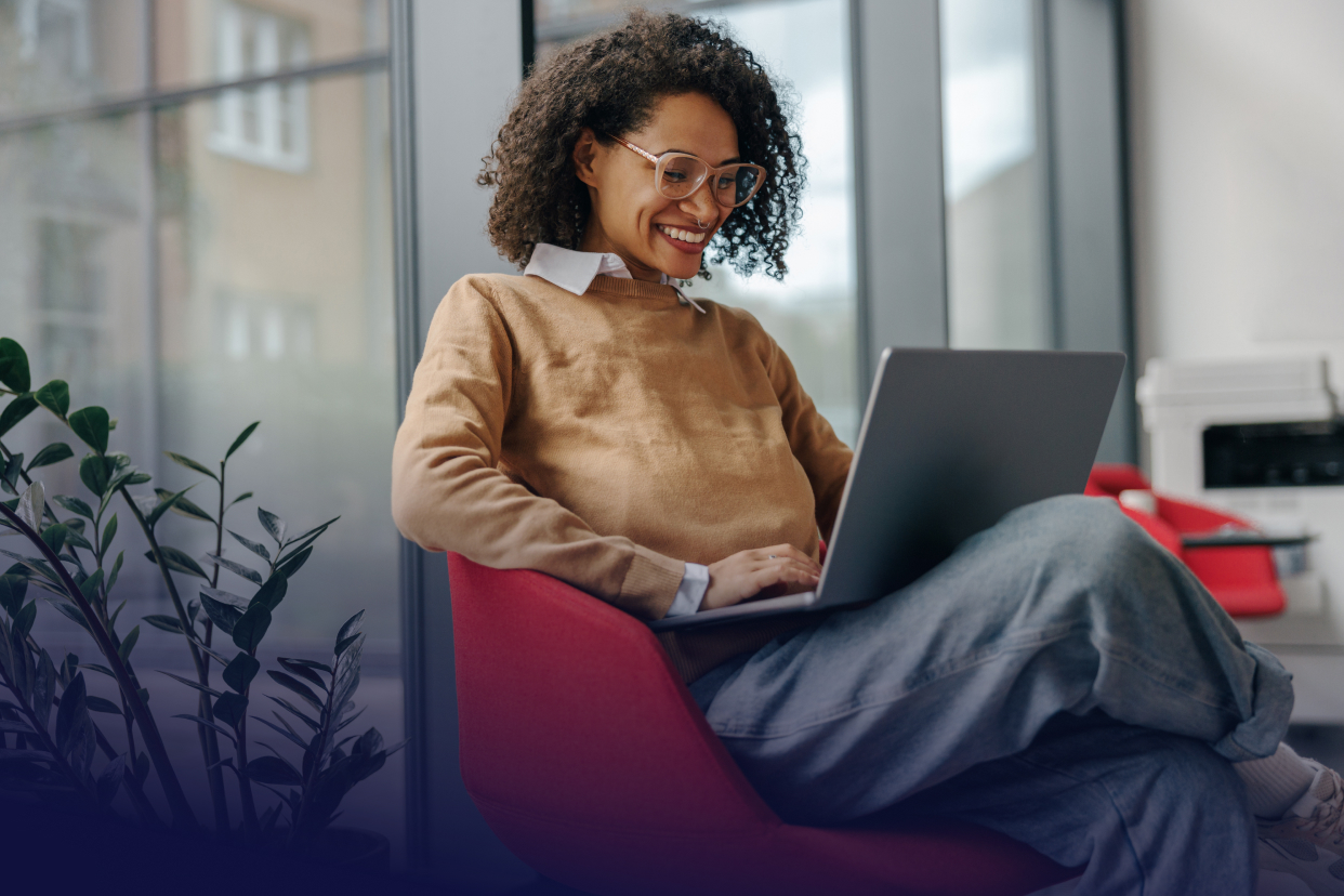 Female office worker working on laptop sitting in chair