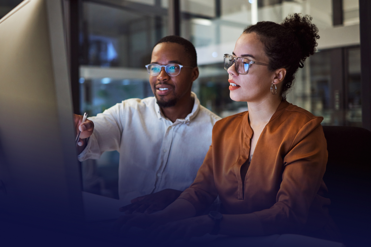 Two office workers looking at computer