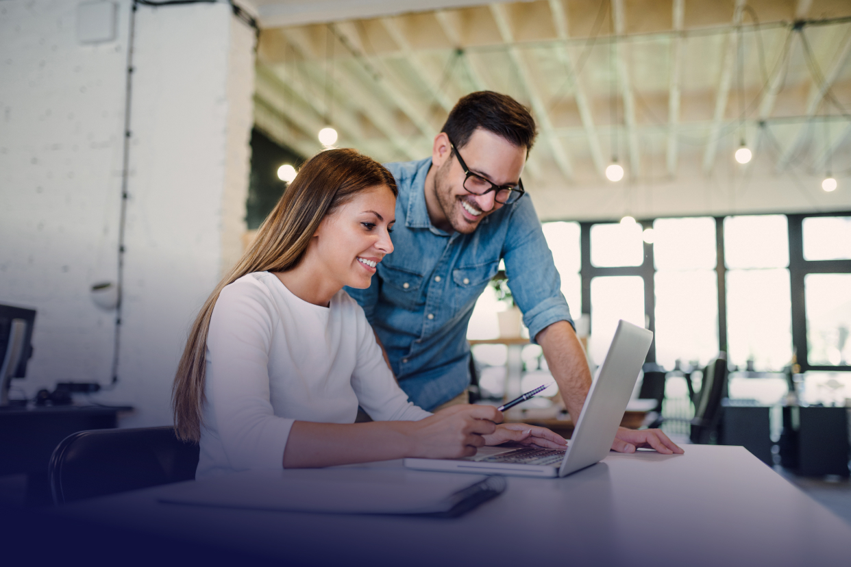 Two office workers looking at laptop