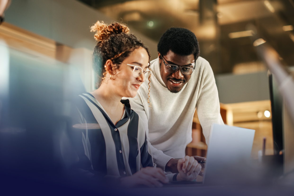 Two office workers looking at laptop