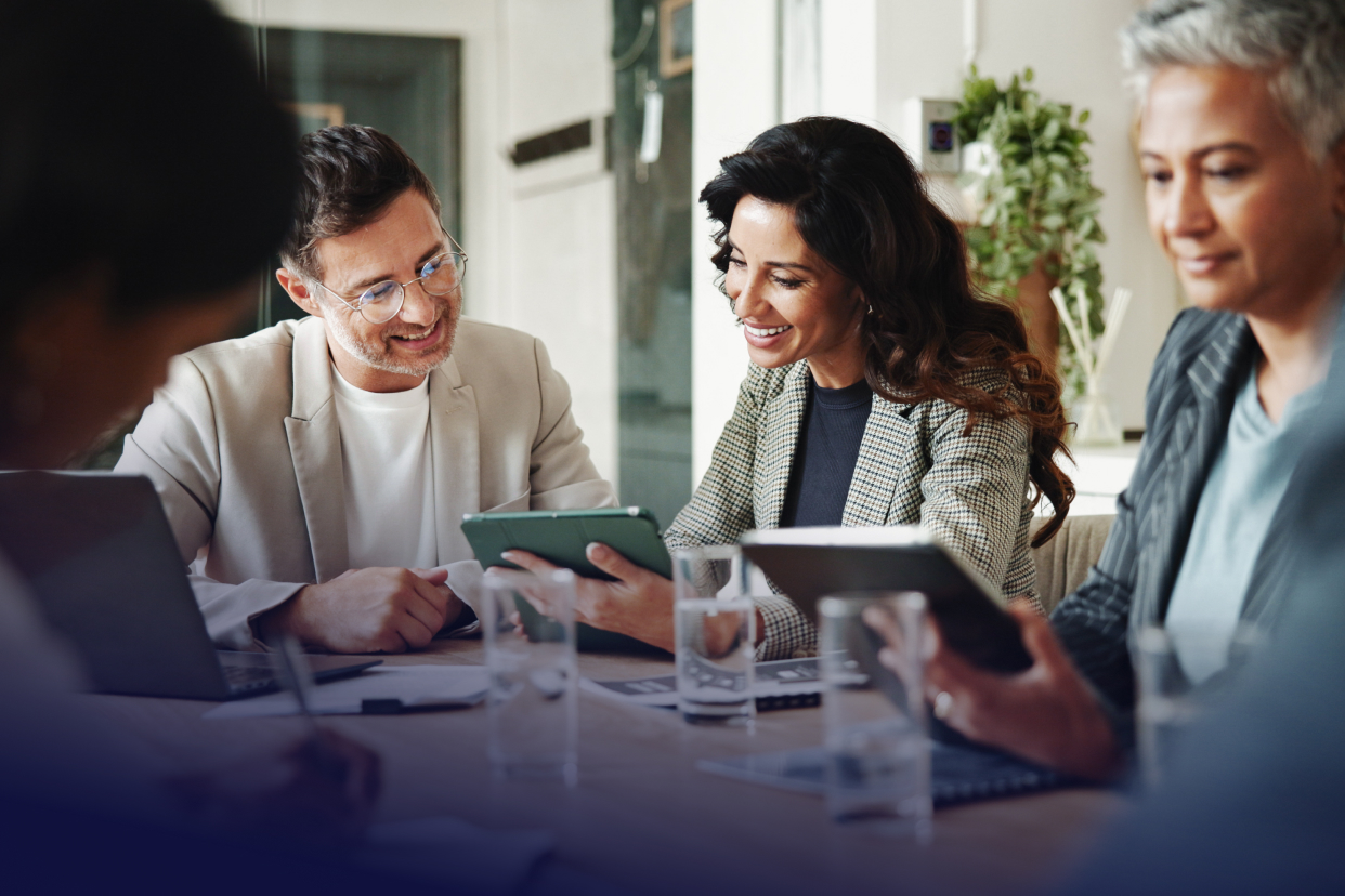 Coworkers on tablet at conference room table