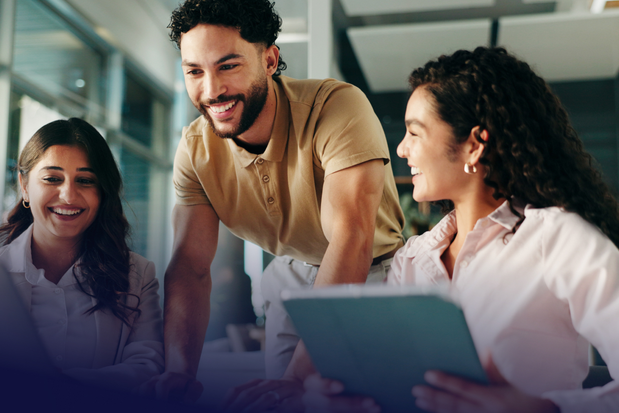 Coworkers working at desk holding tablet